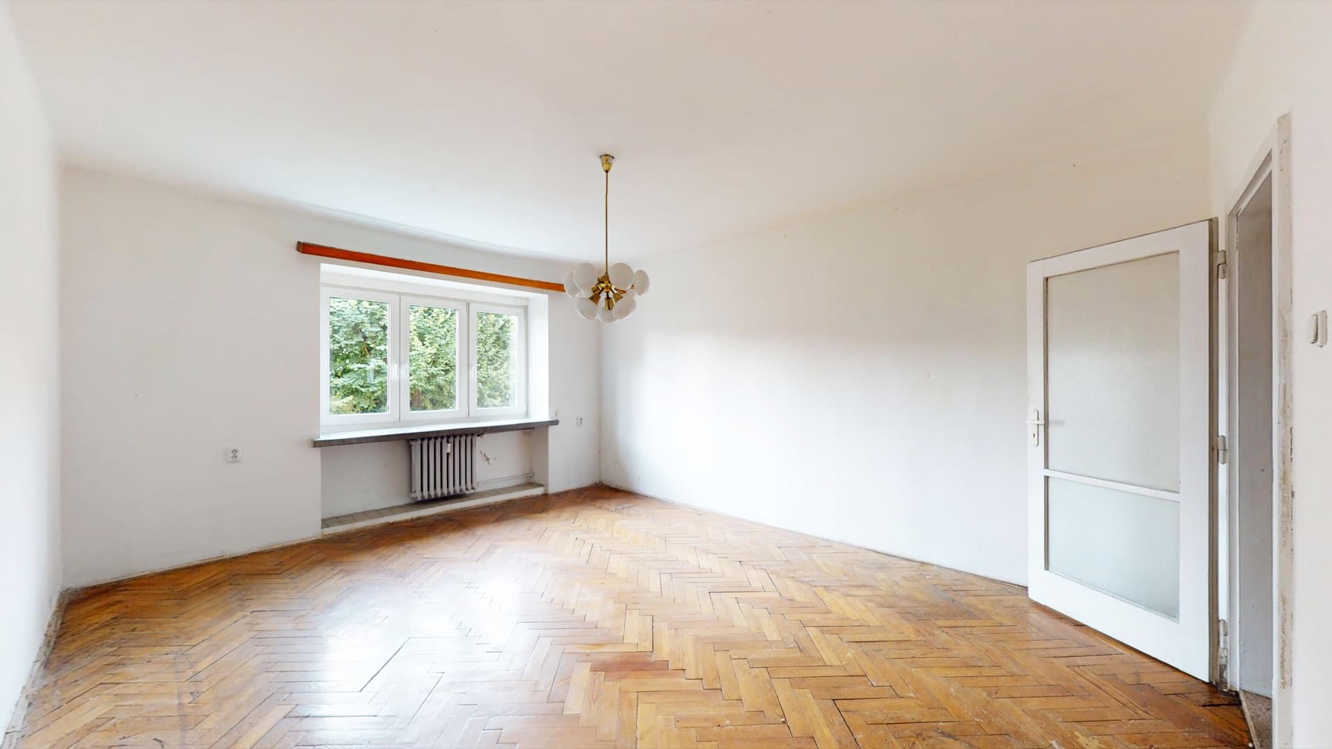 Prostorný obývací pokoj s původními parketami